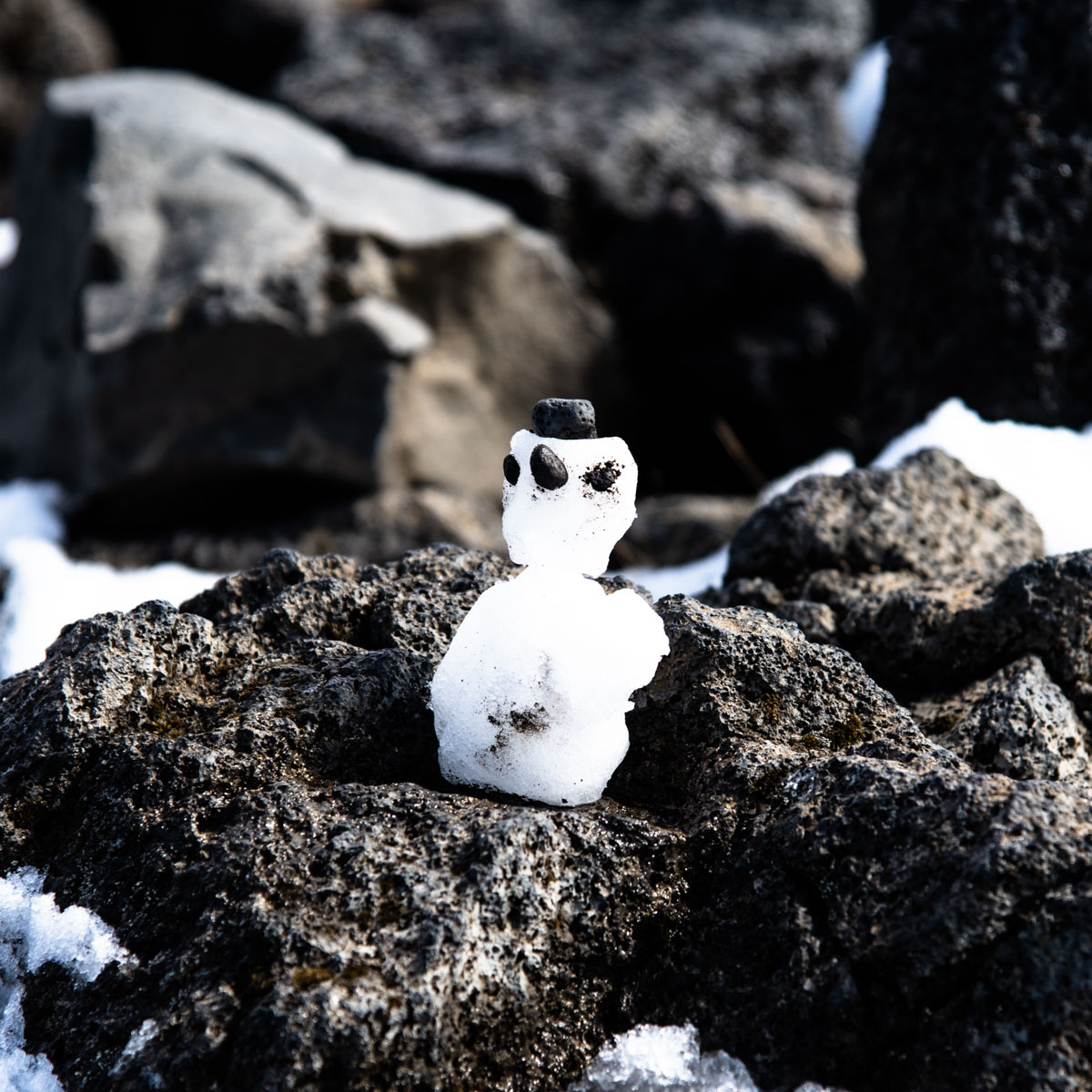 Kleiner Schneemann auf Lavagestein auf Island